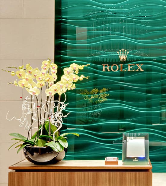 Im Rolex Showroom von Juwelier Jasper gibt es eine grüne Glasvertäfelung mit einem großen goldenen Rolex Logo